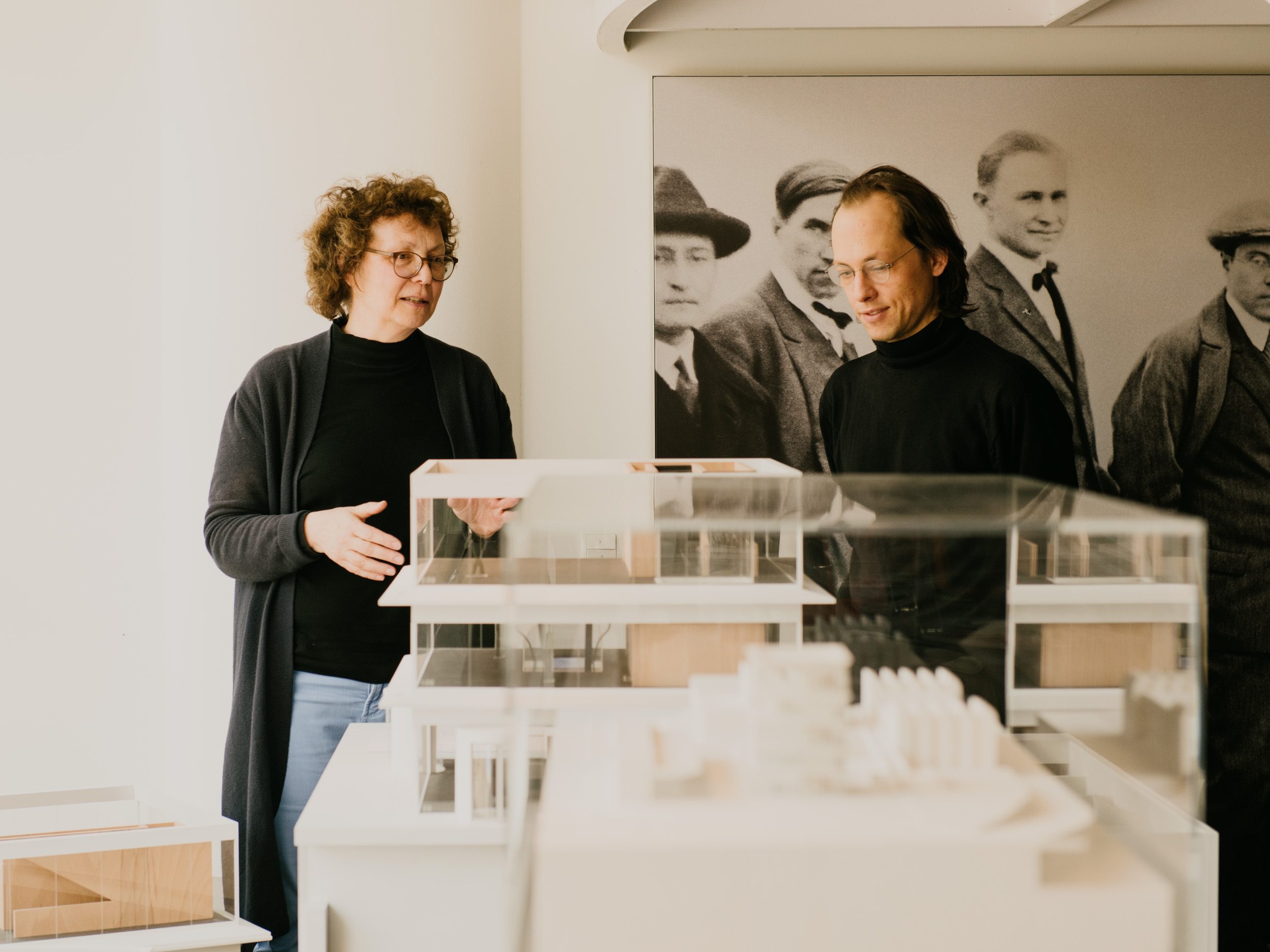 Foto von Annemarie Jaeggi und Philipp Hindahl das weiße architektonische Modell des zukünftigen Bauhaus-Archivs betrachten und diskutieren.