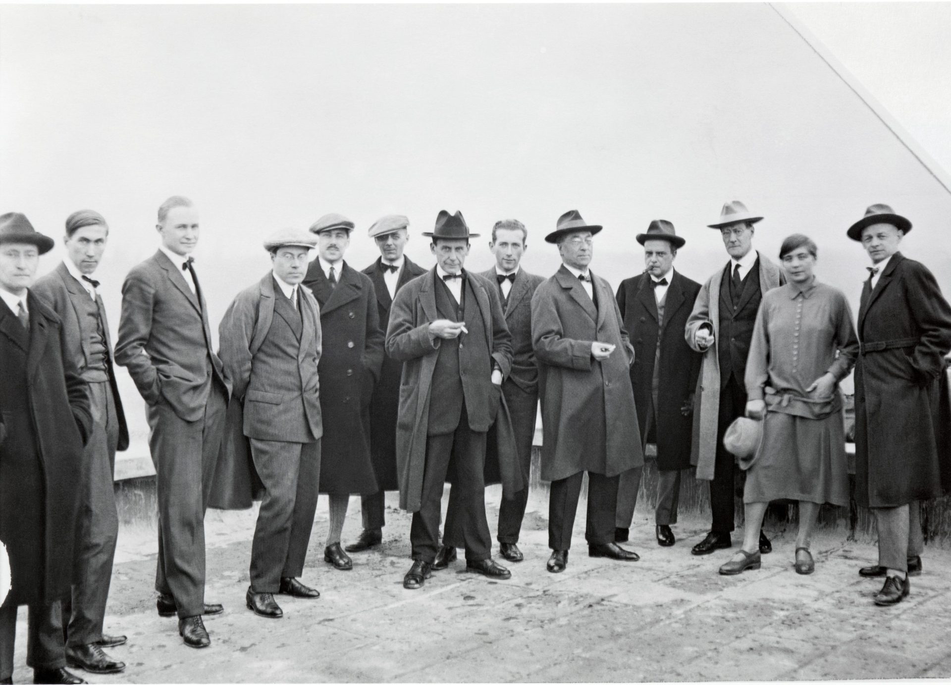 Die Bauhaus-Meister in formeller Kleidung, posierend vor neutralem Hintergrund.