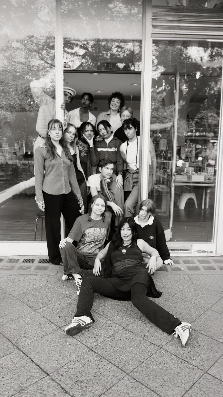 Schwarz-Weiß-Foto einer Gruppe junger Menschen, die in einem Türrahmen stehen, sitzen, liegen.
