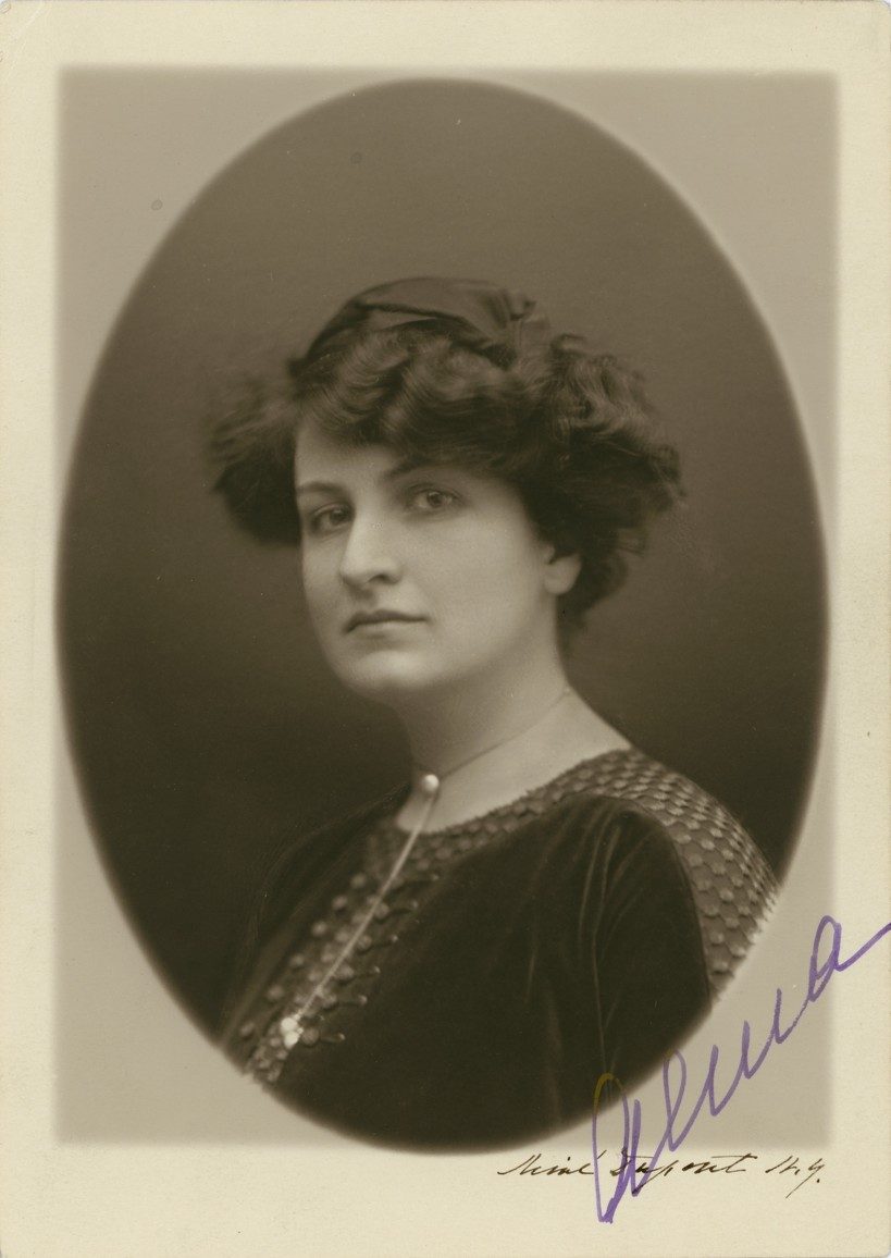 Portrait of a woman from the 1920s with curly hair, an elegant dress, and an oval frame. Signed.