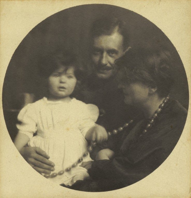 Family portrait featuring a man, a woman, and a child in traditional clothing, surrounded by a round frame.