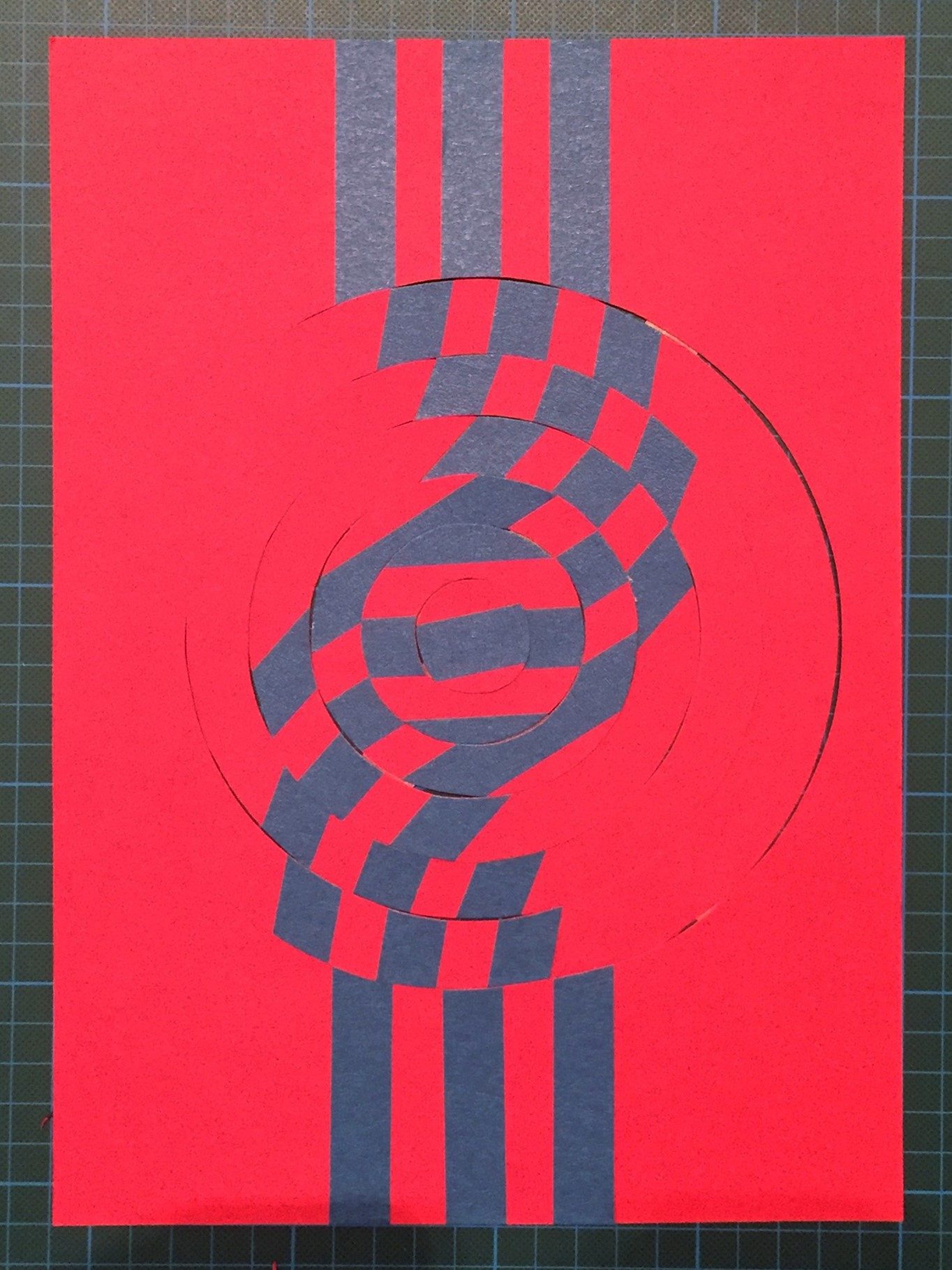 Abstract paper art in red and blue featuring spiral and striped elements.