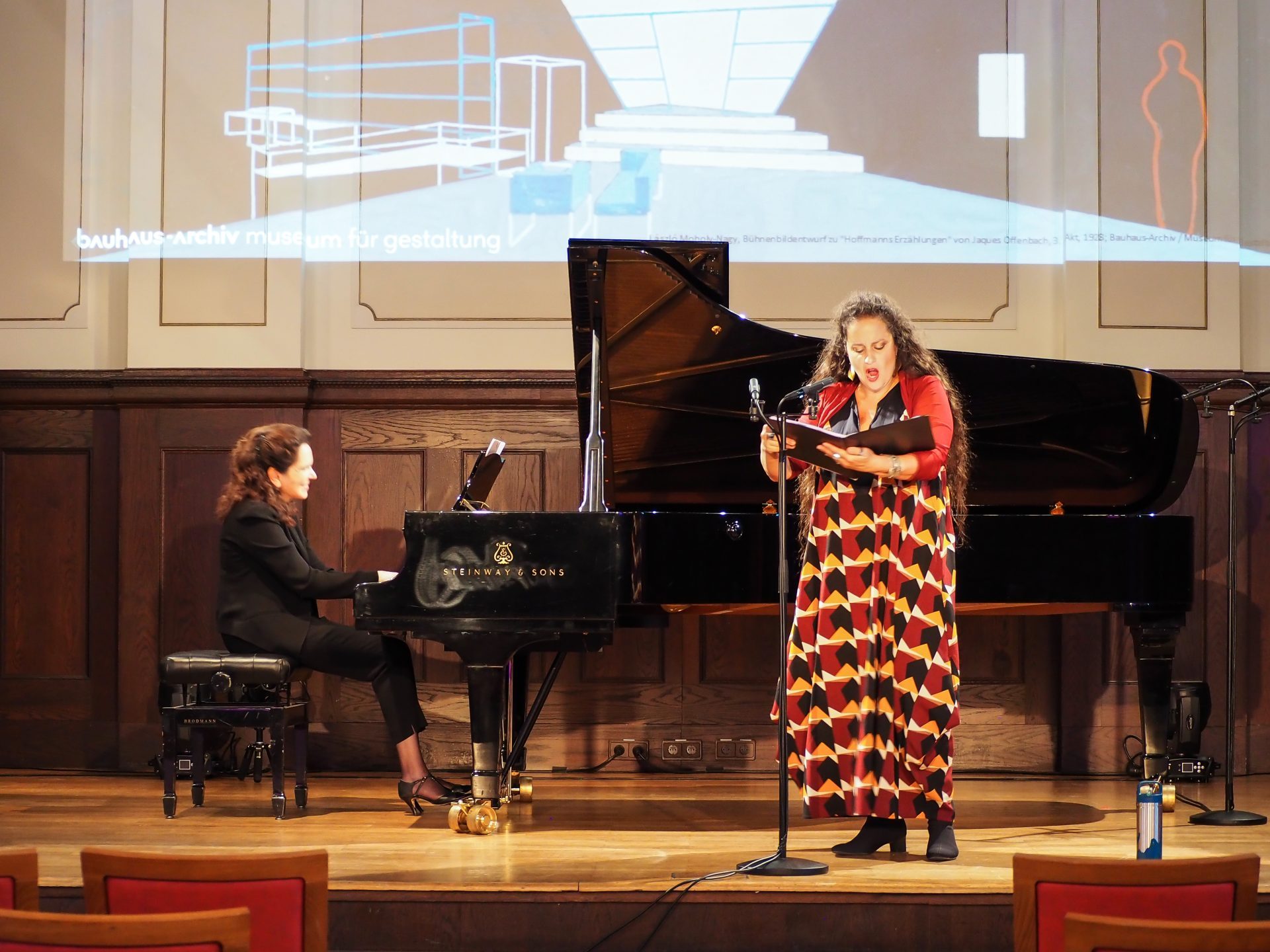 Music and performance event at the Bauhaus Archive with a pianist and performer on stage.