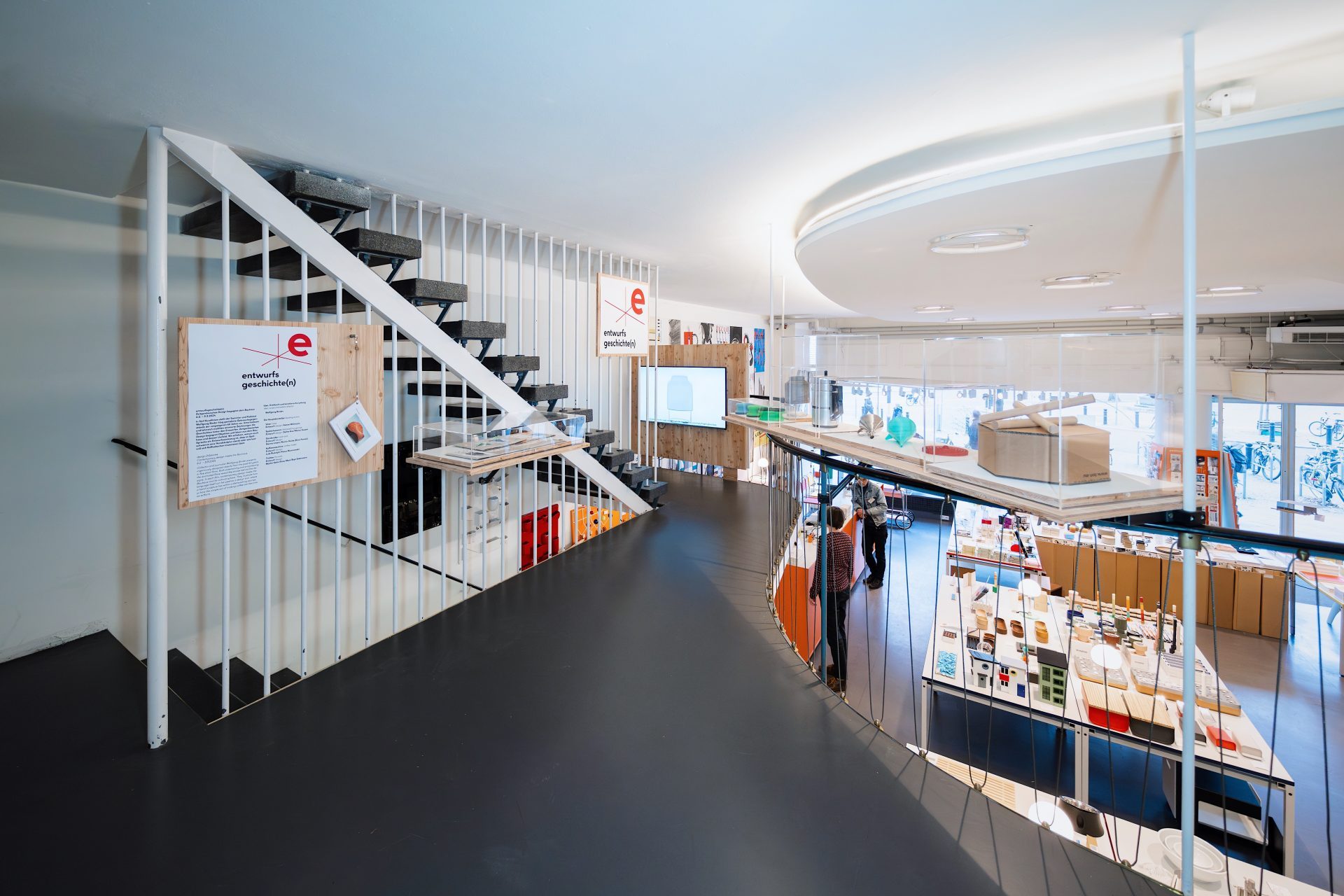 Moderne Innenarchitektur mit Treppe, Ausstellungs- und Verkaufsbereich in einem hellen, offenen Raum.
