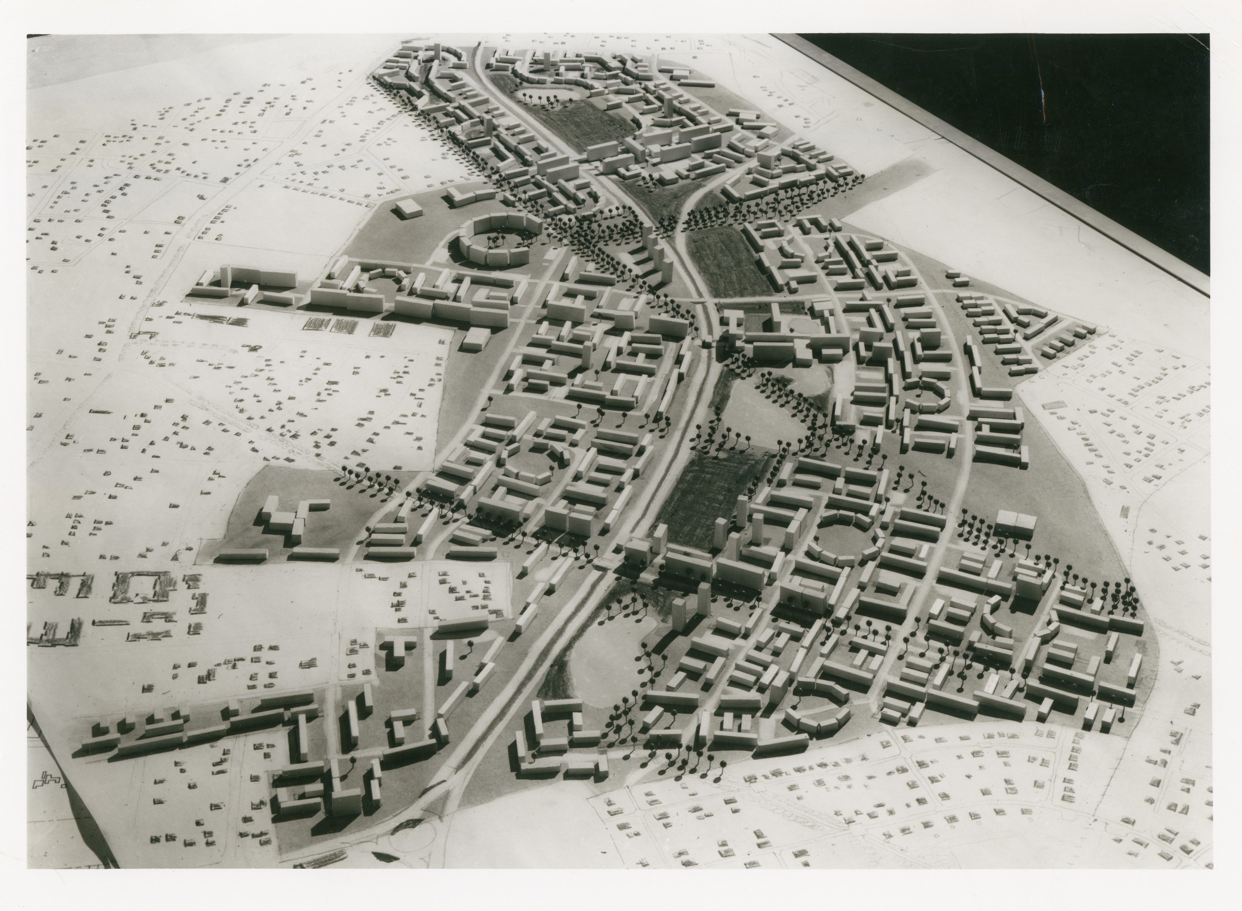 Modell einer Stadtplanung in Schwarz-Weiß mit Gebäuden, Straßen und Landschaftselementen.