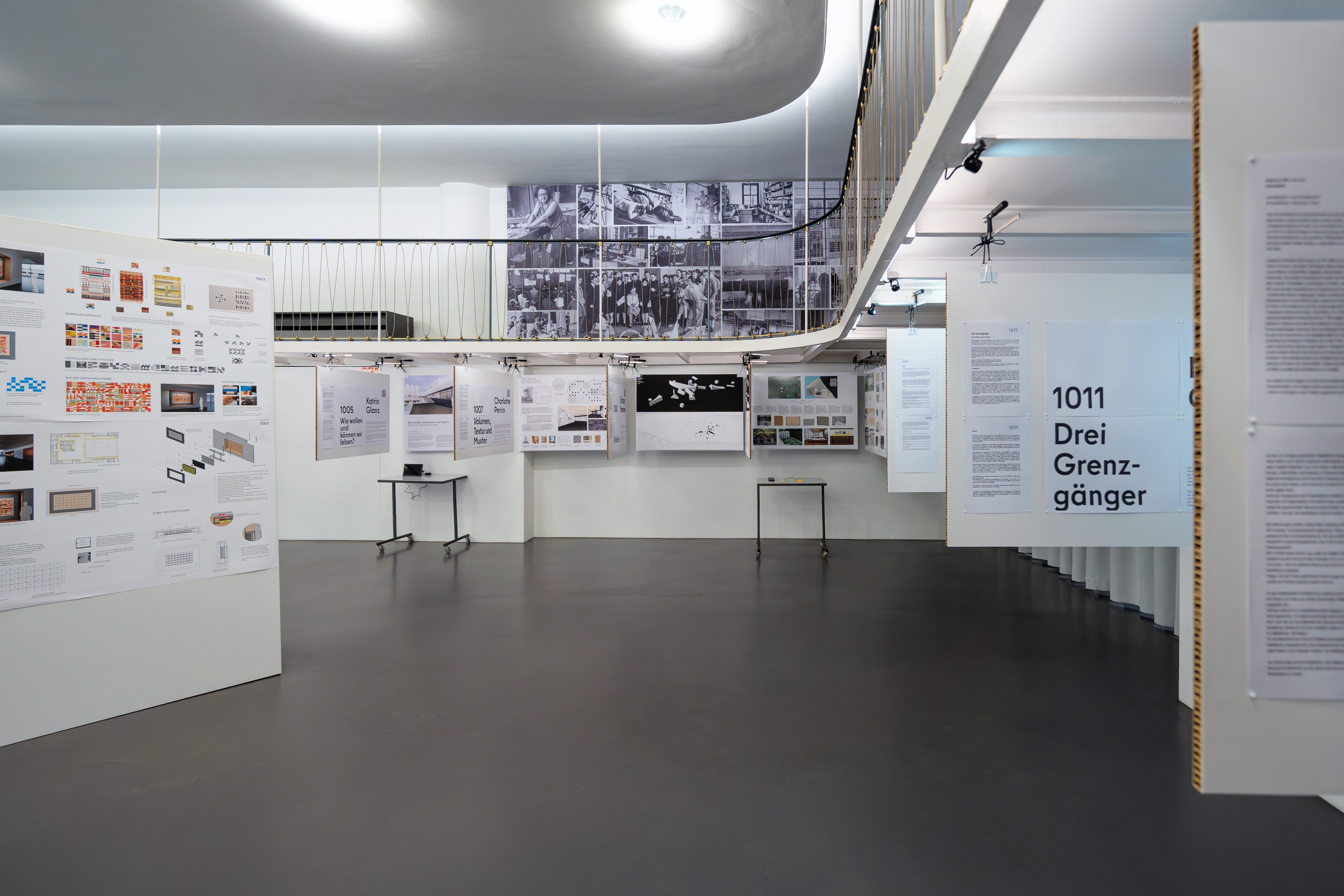 Ausstellungsraum mit informativen Tafeln und einem Tisch im modernen, minimalistischen Design.