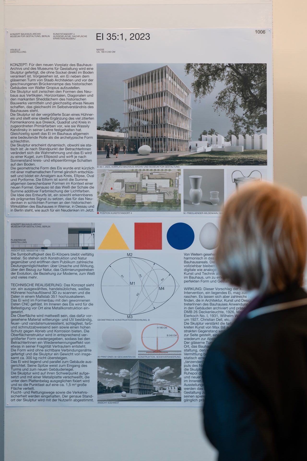 Eine Person schaut sich ein Informationsplakat über Architektur mit Bildern und geometrischen Formen an.