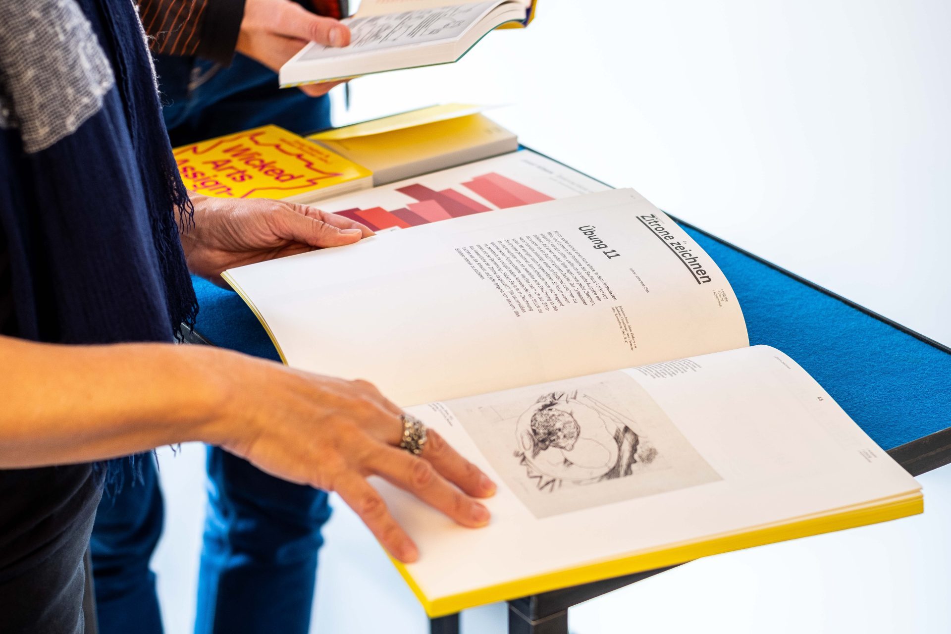 Nahaufnahme von Händen, die durch Bauhaus-Bücher blättern