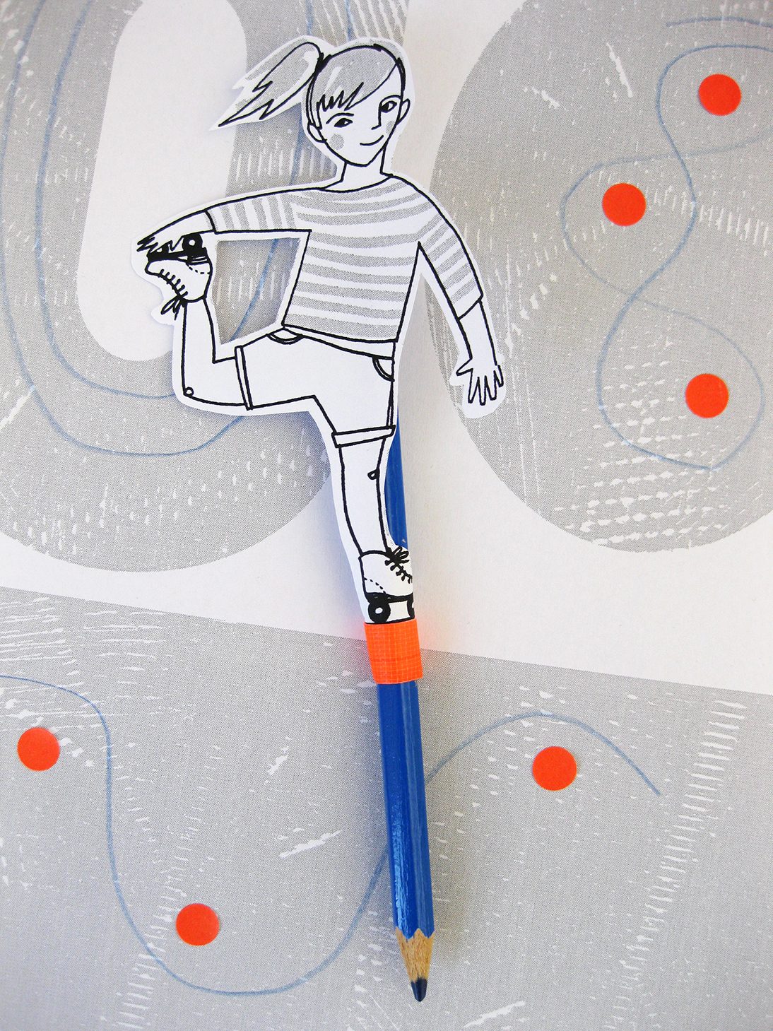 Ein bunter Stift mit einer Puppe, die auf einem Fuß balanciert, umgeben von orangefarbigen Punkten.