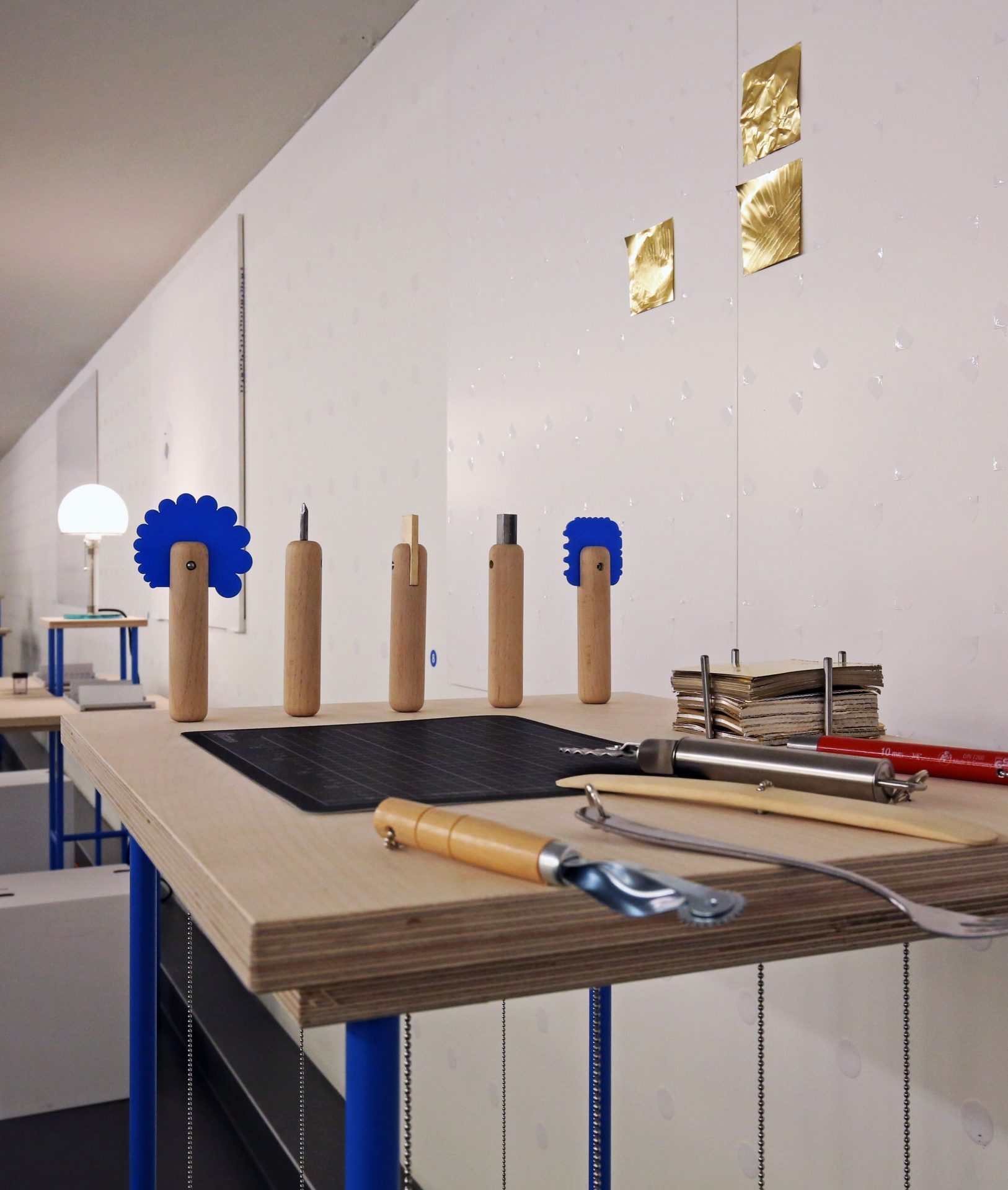 Holztisch mit Werkzeugen und Dekorationselementen vor einer modernen Wand.