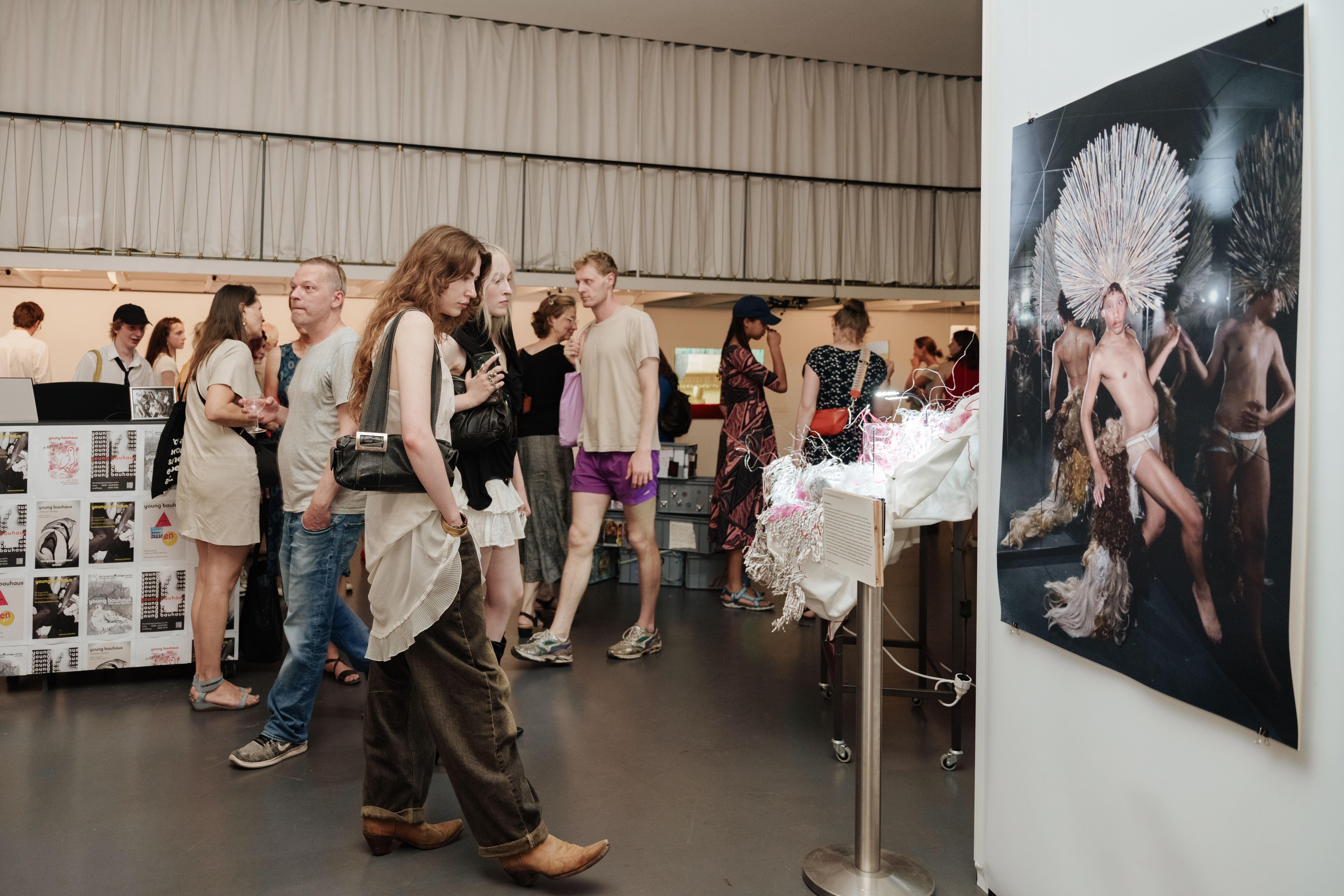 Viel besuchte Kunstausstellung mit verschiedenen Besuchern und beeindruckenden Kunstwerken an der Wand.