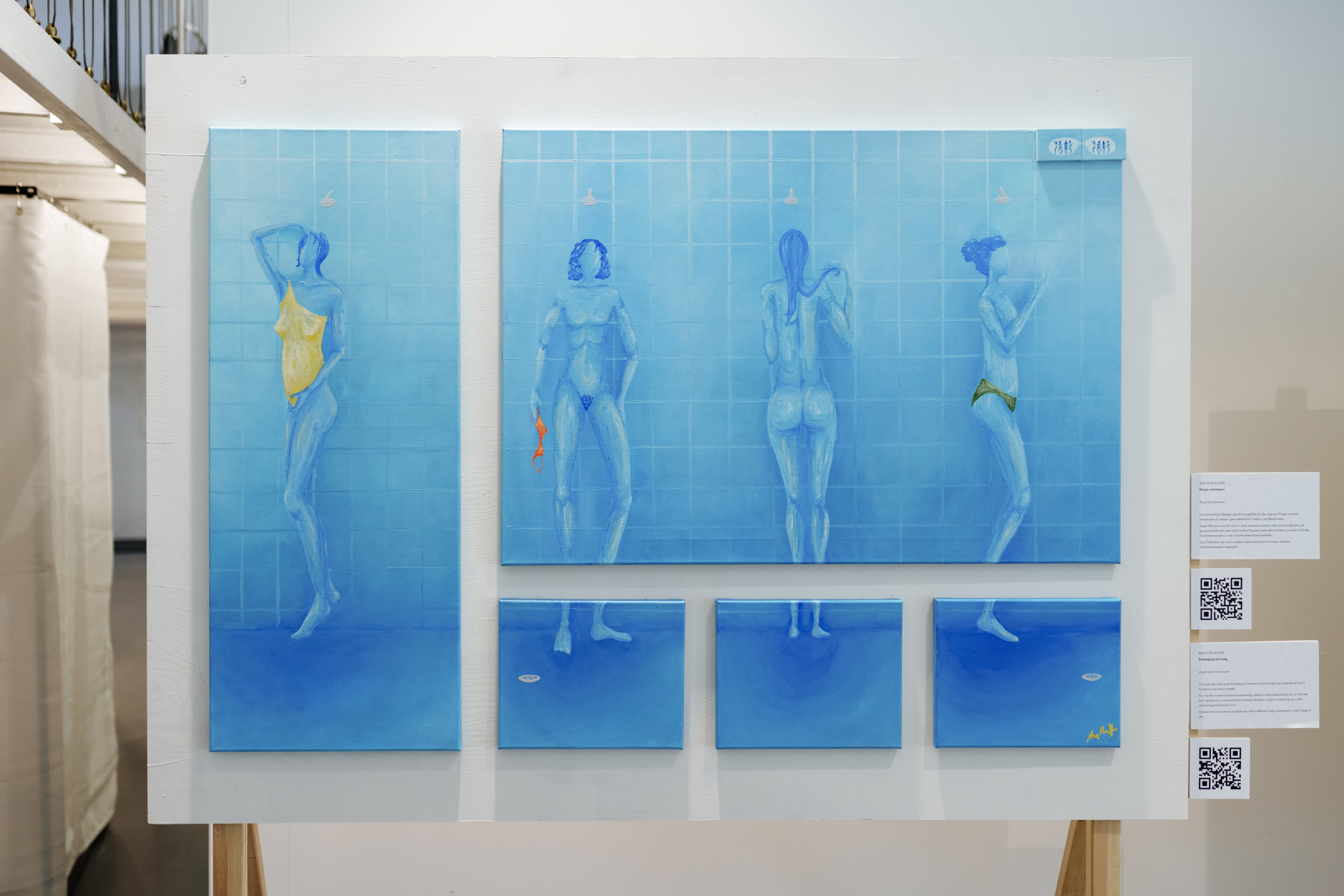 Vier stilisierte Figuren in Blautönen in Schwimmkleidung auf einem kunstvollen Wandgemälde.