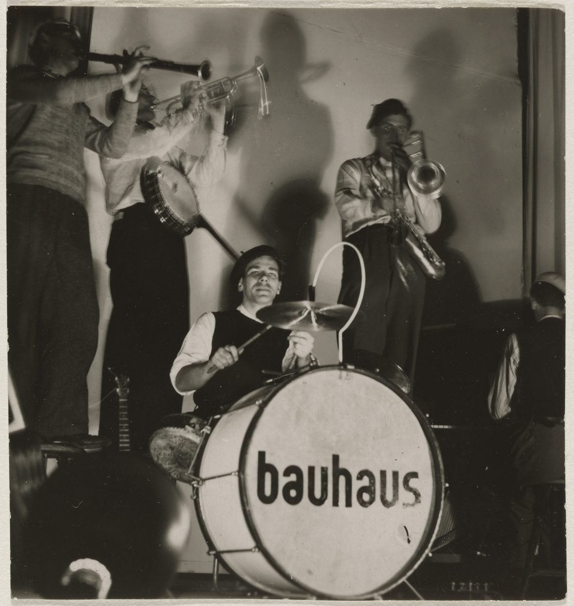 Jazzband mit Trompete, Banjo und Schlagzeug, das „Bauhaus“ auf der Bassdrum zeigt. Schwarz-Weiß-Fotografie.