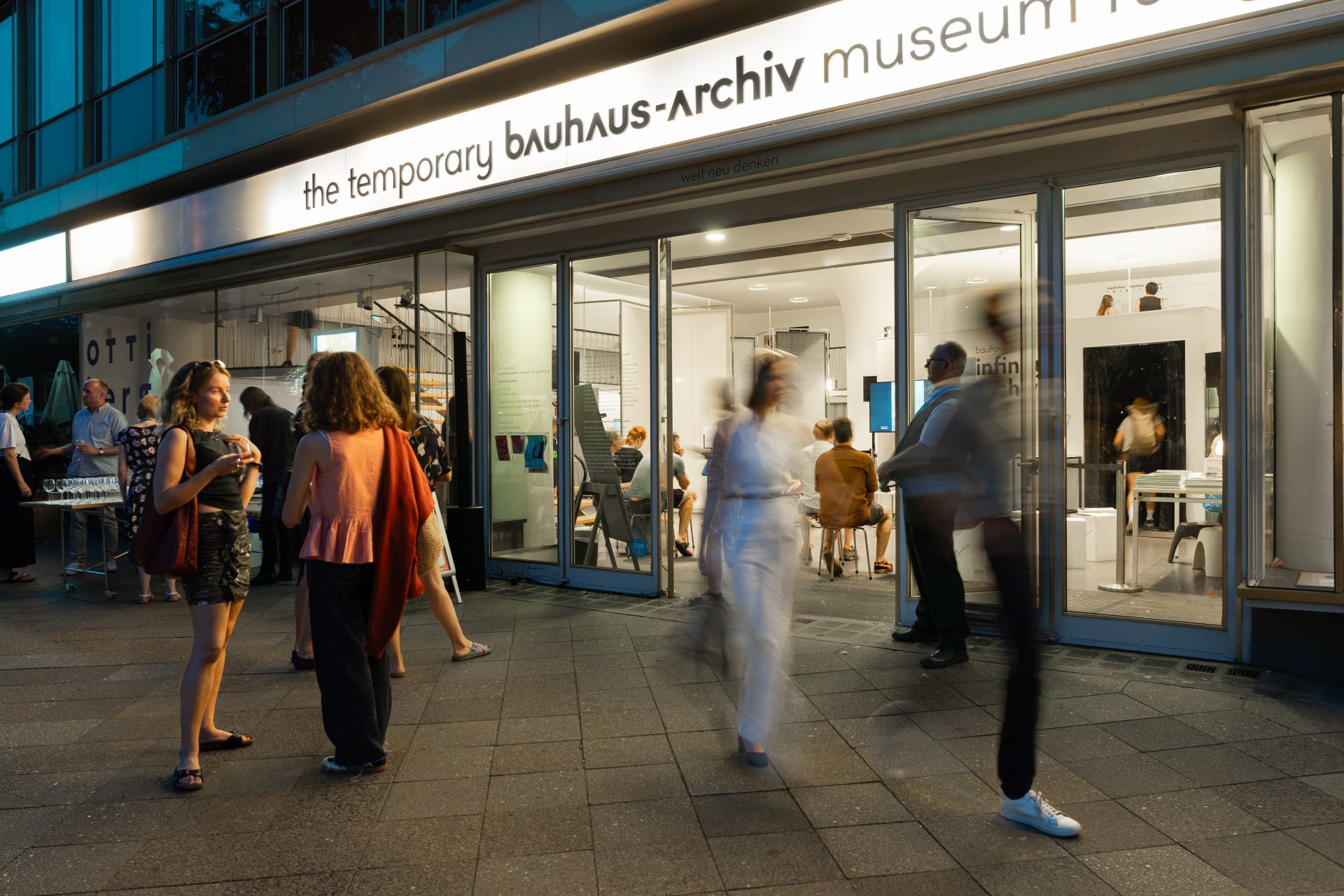 Menschen stehen vor dem temporären Bauhaus-Archiv, während drinnen eine Ausstellung eröffnet ist.