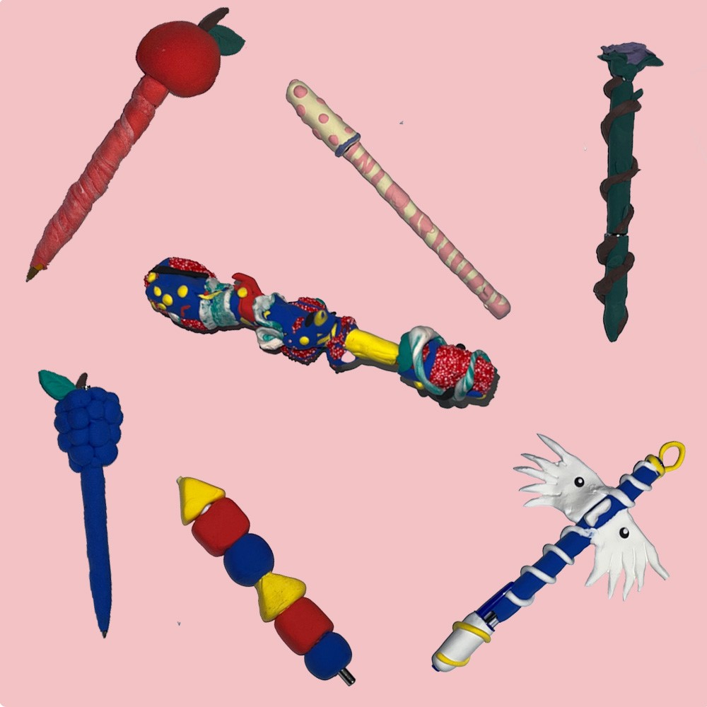 Bunte Stifte aus Knete auf rosanem Untergrund.