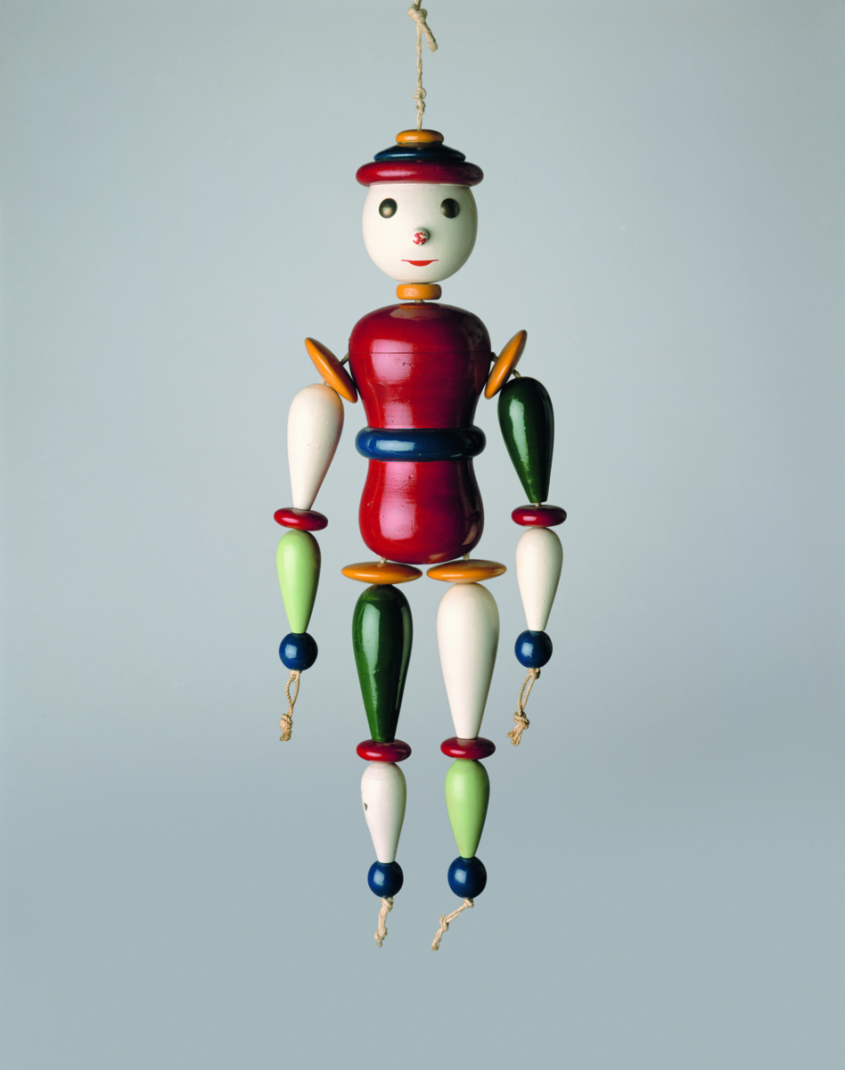 Bunte Holzmarionette mit beweglichen Gliedern, hängend vor einem hellen Hintergrund.