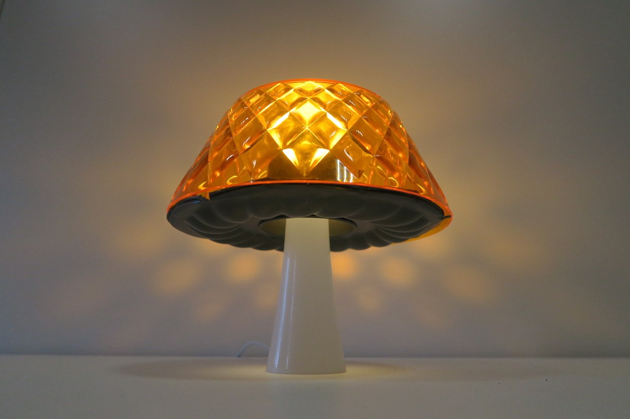 Zu sehen sind Personen, die versammelt um einen Tisch, versuchen verschiedene bunte Tuppergefäße zu Lampen zusammenzustecken.