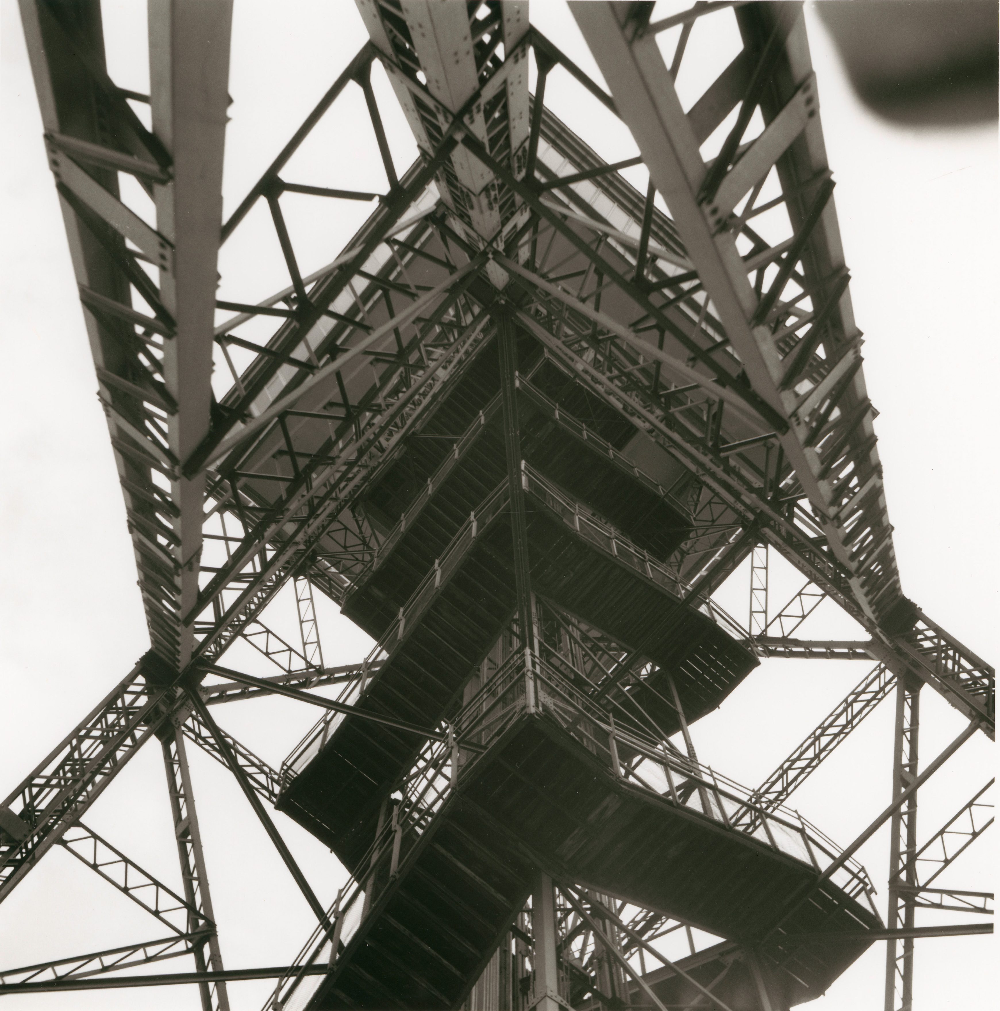 Blick auf die charakteristische Stahlstruktur eines Turms, von unten in Schwarz-Weiß aufgenommen.