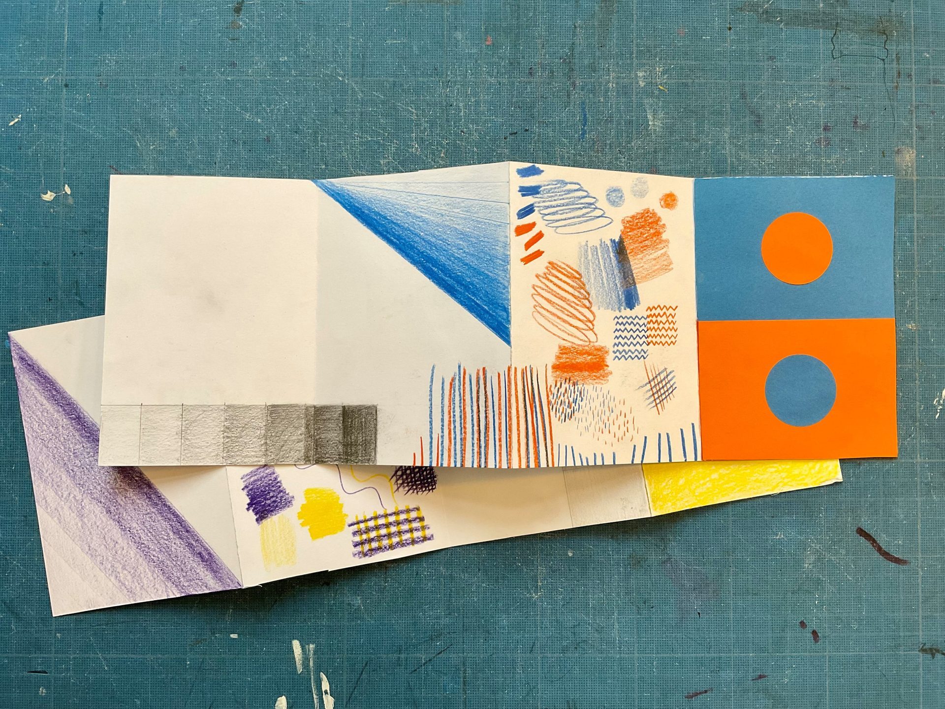 Faltbuch mit bunten Zeichnungen und Mustern auf einem blauen Hintergrund.