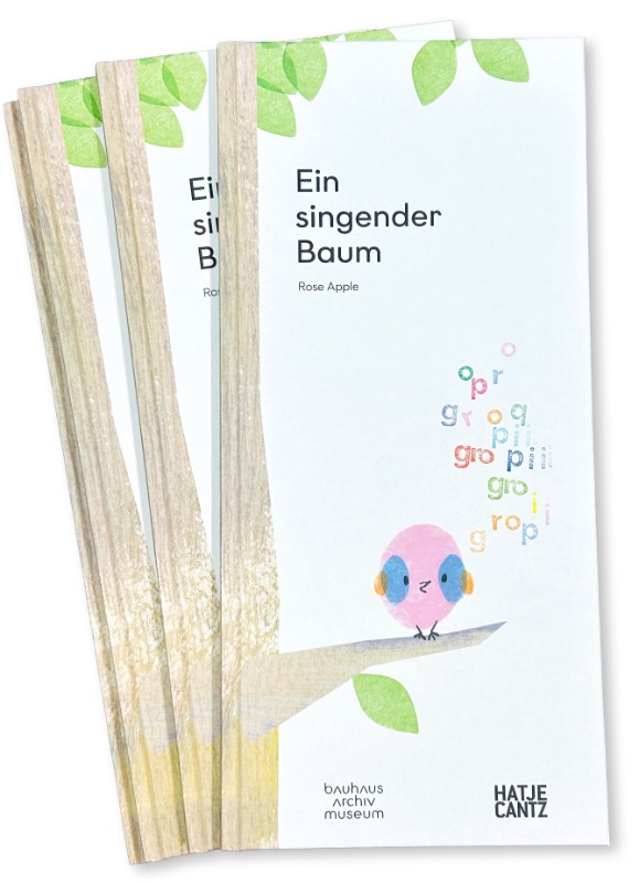Drei Bücher mit dem Titel „Ein singender Baum“ von Rose Apple, illustriert mit einem bunten Vogel auf einem Ast.