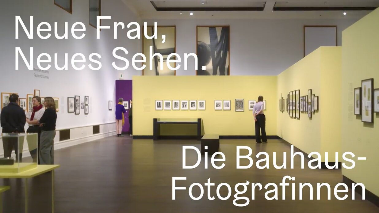 Ausstellung im Museum mit bunten Wänden und Bildern, Betrachter entdecken Bauhaus-Fotografien.