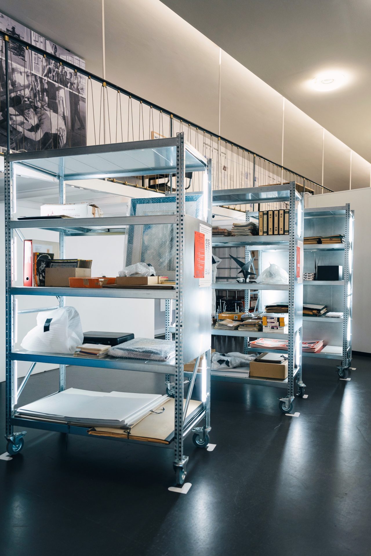 A regal display in a modern room, filled with various materials and tools, backlit for better visibility.