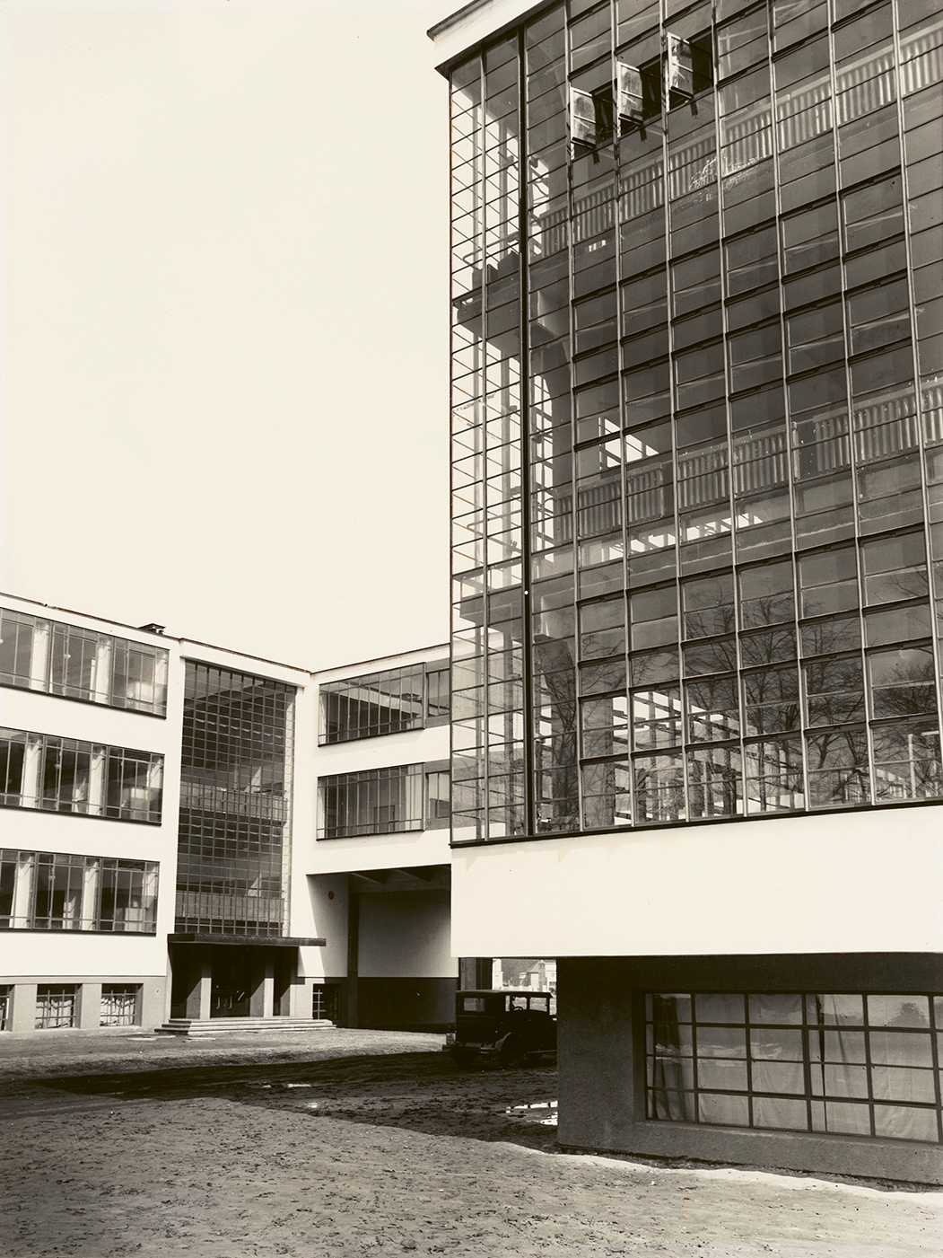 Modernes Gebäude mit großen Glasfenstern, geometrischem Design und einem klaren Blick auf den Innenhof.